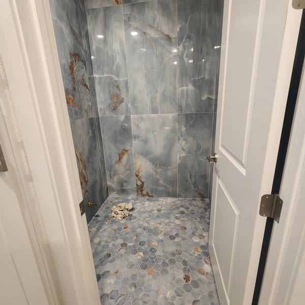 Blue veined tile shower with niche