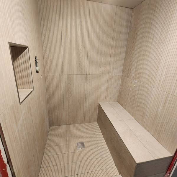 Shower with ribbed wall tile and a bench
