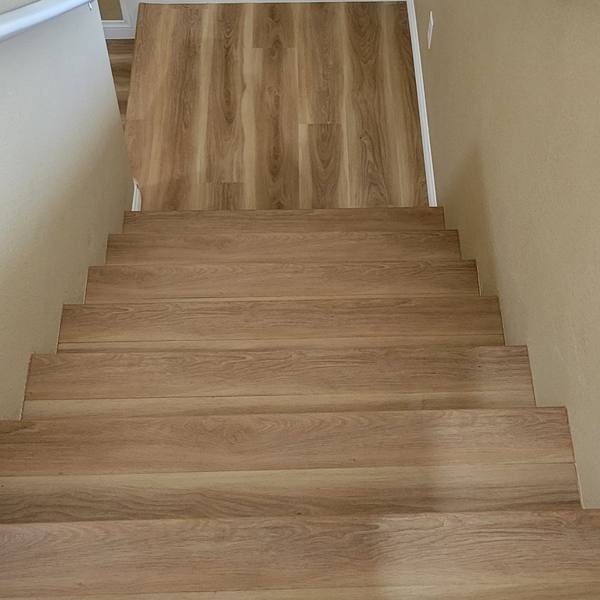 Light oak stair treads leading down to a matching plank floor