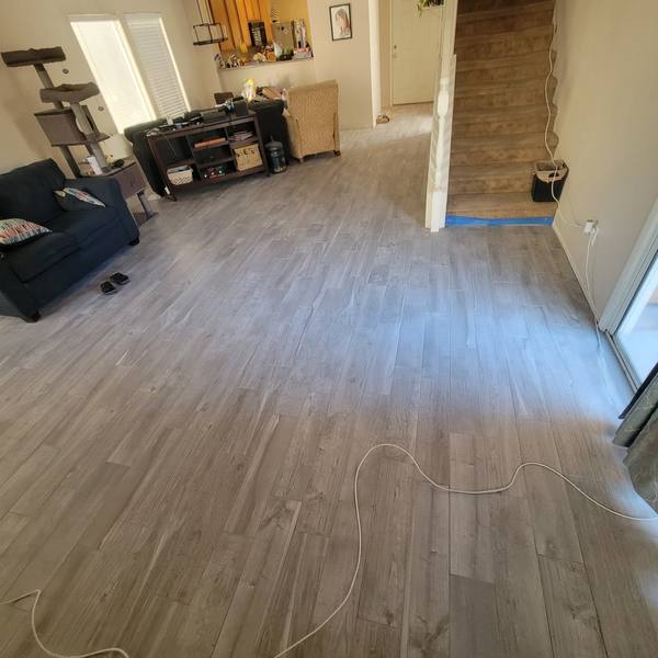 Gray wood-look plank tile from the living room to the stairs