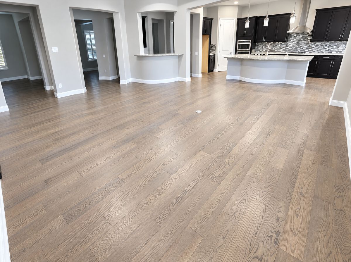 Wide-plank engineered hardwood through an open great room and kitchen, installed by Tile Max Flooring
