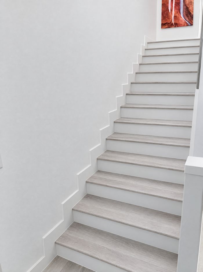 Same staircase finished with light gray treads and white risers