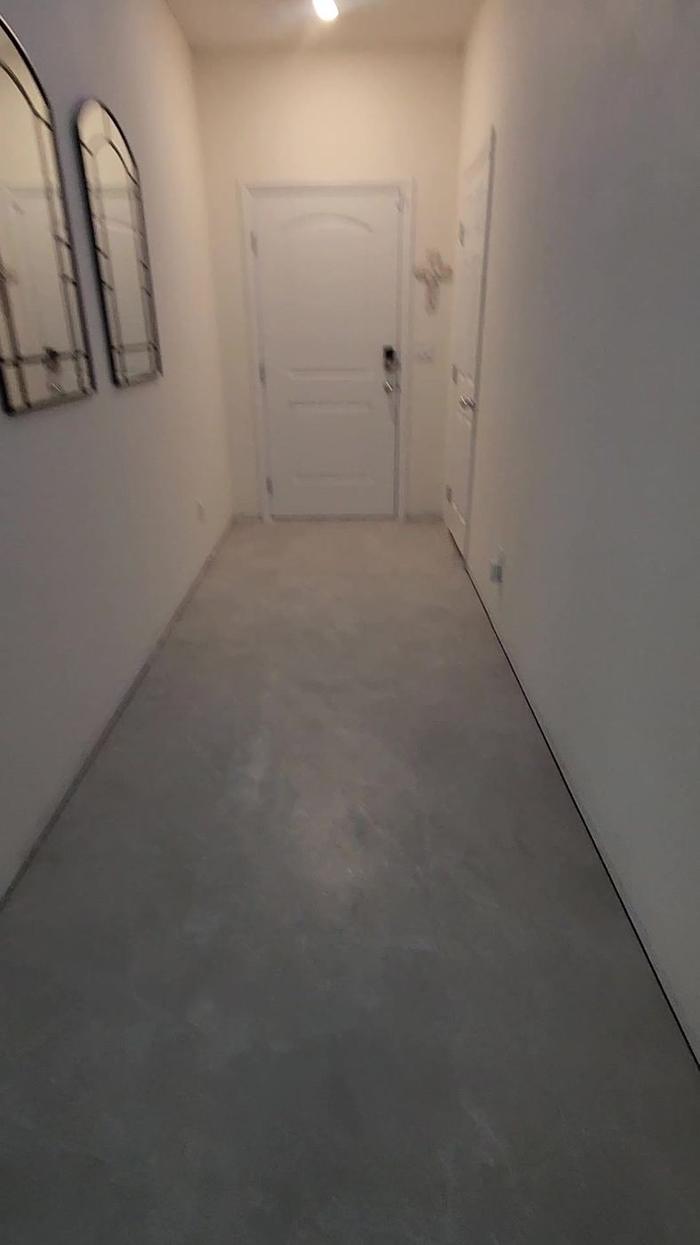 Hallway to the front door on bare slab before tile