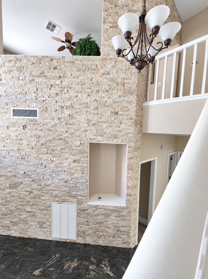 Finished two-story stacked-stone entry wall with niches