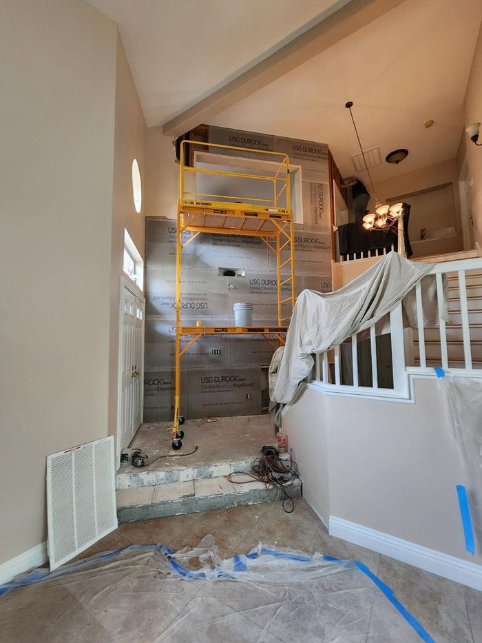Entry wall covered in cement board with scaffolding before stone