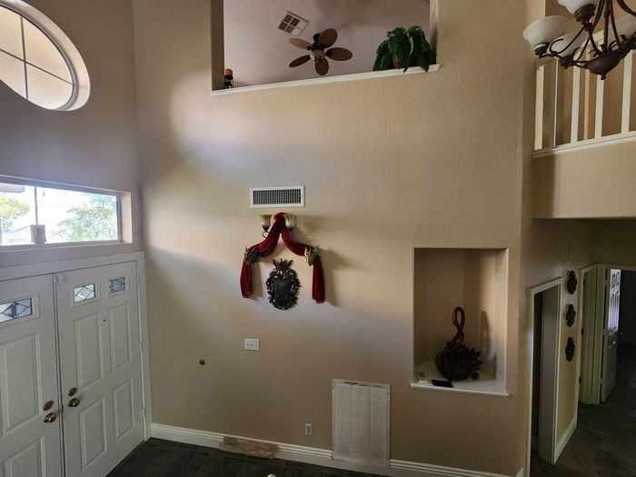 Plain two-story entry wall with niches before stone