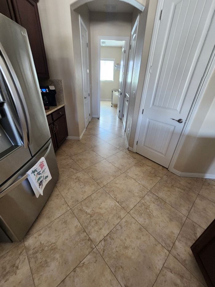 Old tan tile laid on the diagonal by the kitchen, before removal